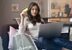 Woman sitting down with a laptop and credit card in hand